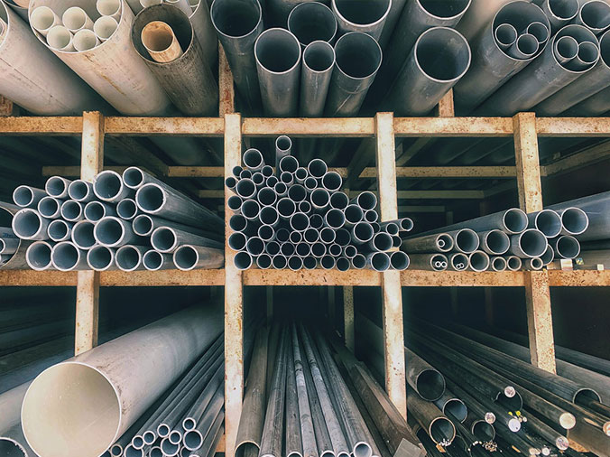 Steel and PVC plumbing pipes in a lpumbing supply distributor warehouse