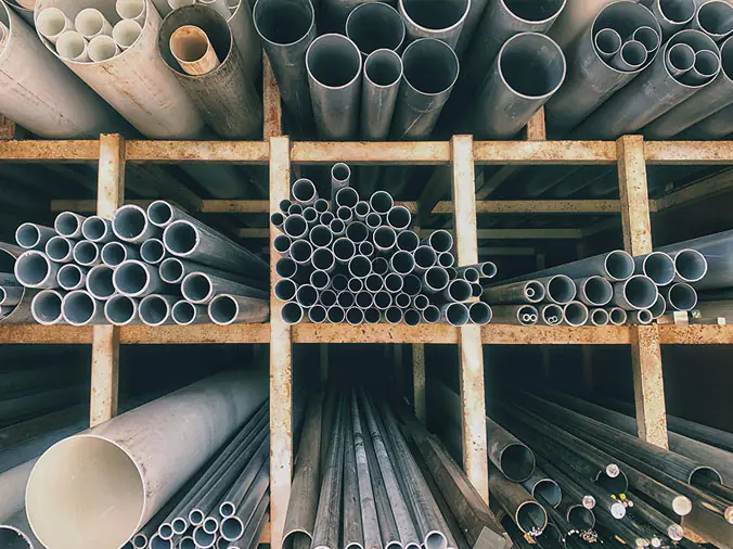 Steel and PVC plumbing pipes in a lpumbing supply distributor warehouse